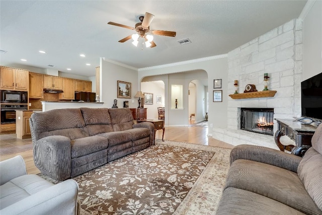 living area with arched walkways, a ceiling fan, crown molding, recessed lighting, and baseboards