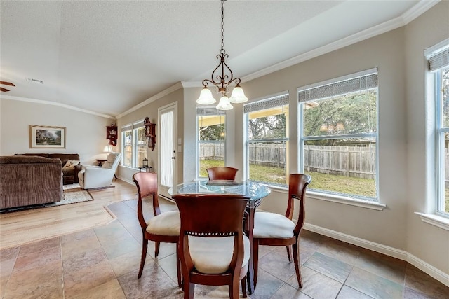 dining area featuring plenty of natural light, a chandelier, ornamental molding, baseboards, and vaulted ceiling