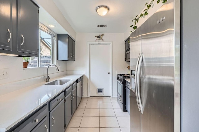 7605 Clydesdale Dr, Austin, TX 78745 - kitchen featuring appliances with stainless steel finishes, light countertops, light tile patterned flooring, and gray cabinets