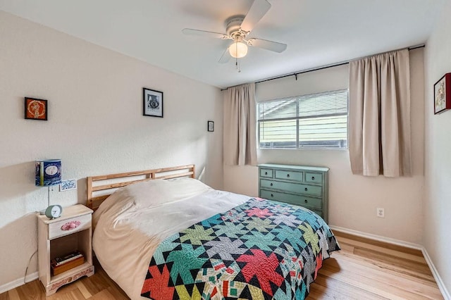 bedroom featuring light wood finished floors, baseboards, and a ceiling fan