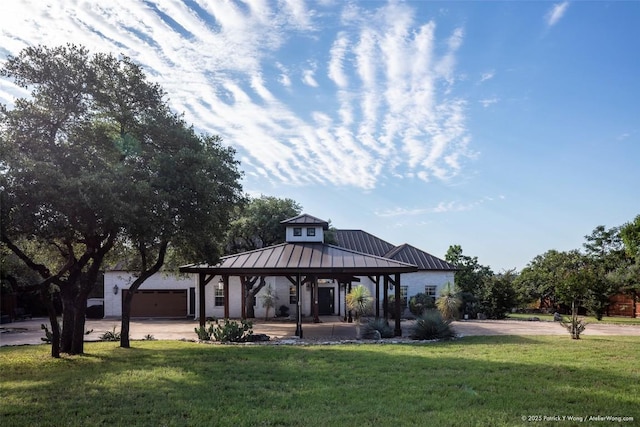 view of front of house with a gazebo, a front yard, metal roof, driveway, and a standing seam roof