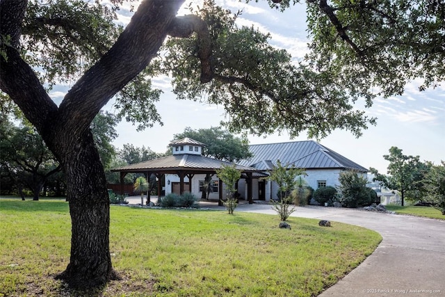 view of front facade featuring a gazebo, a front lawn, and metal roof