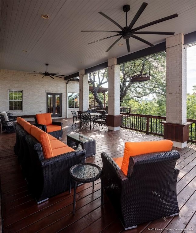 wooden terrace with a ceiling fan, french doors, outdoor lounge area, and outdoor dining area