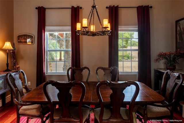 dining space with a chandelier and wood finished floors