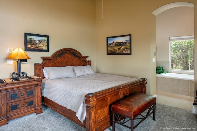 bedroom with carpet floors and arched walkways