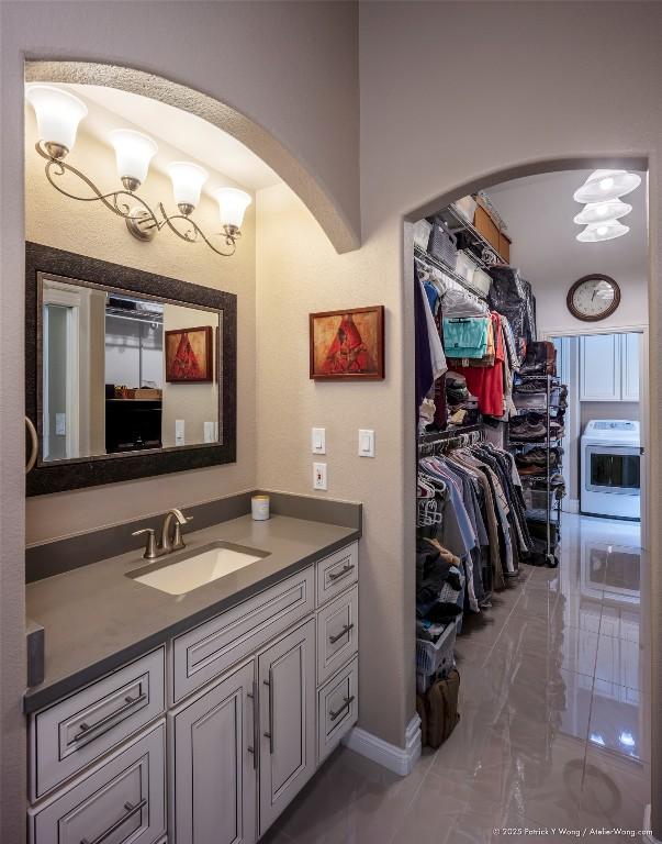 14305 Fallen Timber Dr, Austin, TX 78734 - bathroom featuring marble finish flooring, vanity, a spacious closet, and washer / dryer