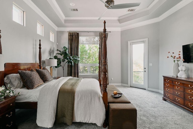 bedroom featuring a tray ceiling, access to exterior, multiple windows, light carpet, and crown molding