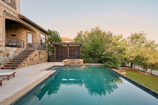 view of pool featuring stairs, a pool with connected hot tub, a patio area, and a yard