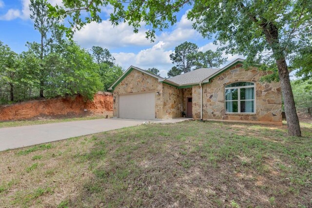 265 Makaha Dr, Bastrop, TX 78602 - ranch-style house featuring stone siding, a garage, and driveway