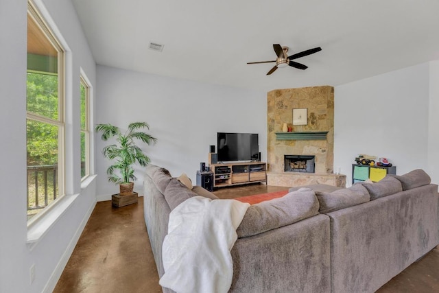 265 Makaha Dr, Bastrop, TX 78602 - living room with finished concrete floors, baseboards, a stone fireplace, and ceiling fan