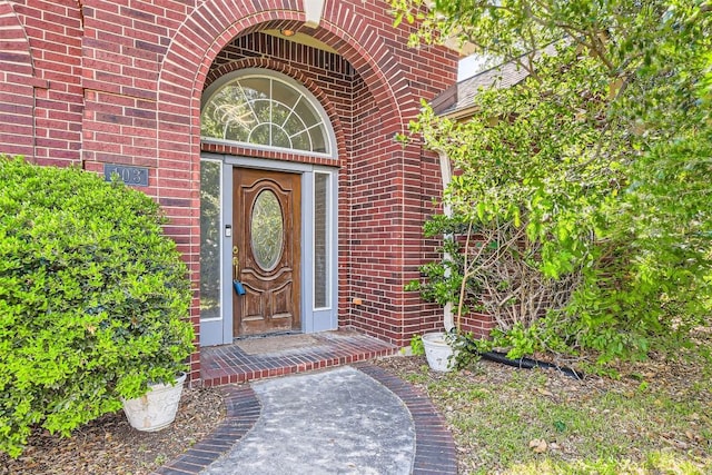property entrance featuring brick siding