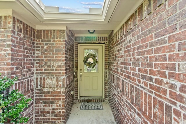 doorway to property featuring brick siding