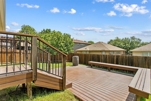 wooden terrace with a fenced backyard