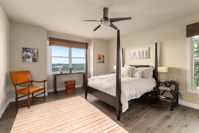 6605 W Courtyard Dr, Austin, TX 78730 - bedroom with wood finished floors, multiple windows, baseboards, and ceiling fan