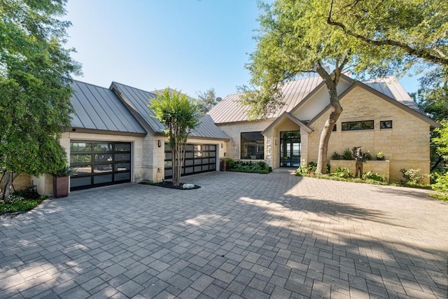 6605 W Courtyard Dr, Austin, TX 78730 - view of front of house with a standing seam roof, a garage, decorative driveway, stone siding, and metal roof