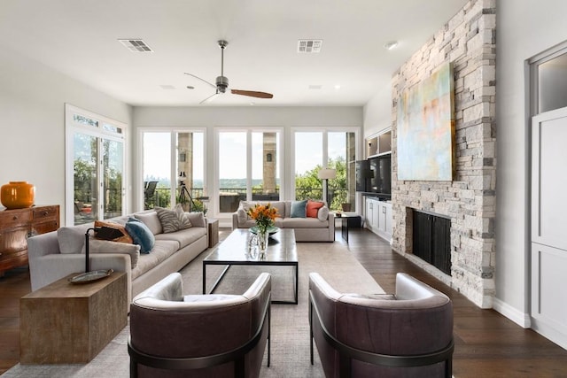 6605 W Courtyard Dr, Austin, TX 78730 - living room featuring ceiling fan, a stone fireplace, dark wood-type flooring, and baseboards