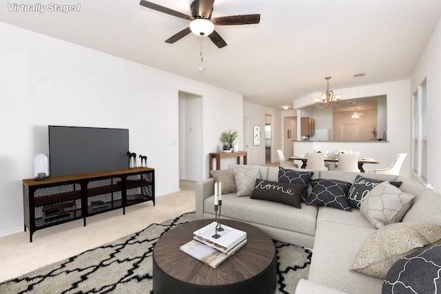 221 Bonham Loop, Georgetown, TX 78633 - living room featuring light carpet, a chandelier, ceiling fan, and baseboards