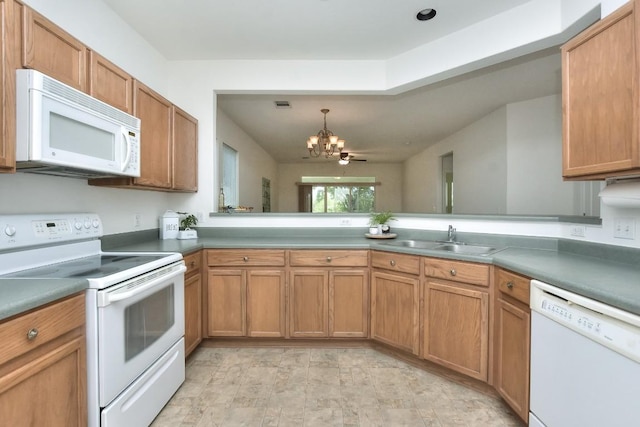 221 Bonham Loop, Georgetown, TX 78633 - kitchen with white appliances, a chandelier, brown cabinets, and hanging light fixtures