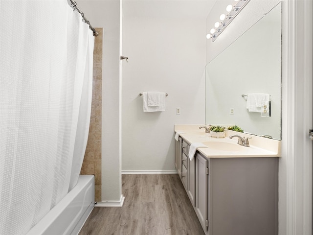 10719 Watchful Fox Dr, Austin, TX 78748 - full bathroom featuring wood finished floors, double vanity, shower / bathtub combination with curtain, and baseboards