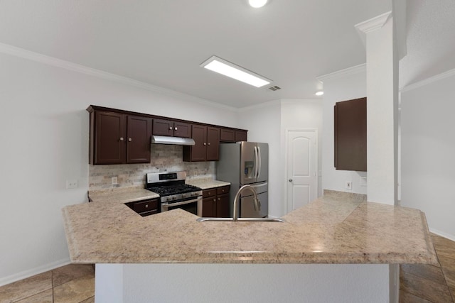 118 Cassandra Dr, Hutto, TX 78634 - kitchen with stainless steel appliances, under cabinet range hood, a sink, a peninsula, and dark brown cabinetry