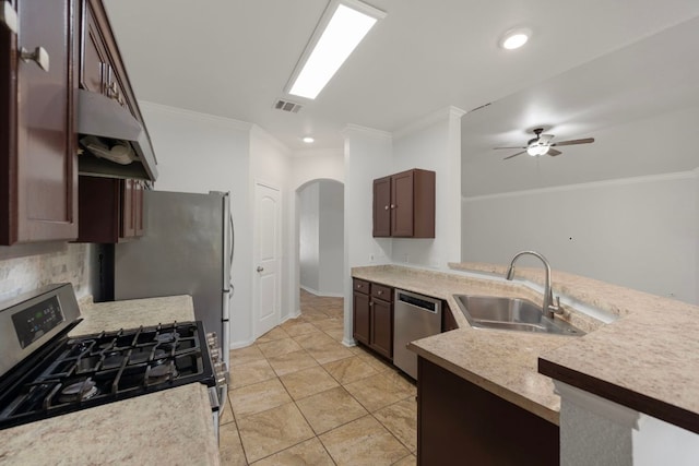 118 Cassandra Dr, Hutto, TX 78634 - kitchen featuring appliances with stainless steel finishes, a sink, arched walkways, ornamental molding, and a ceiling fan