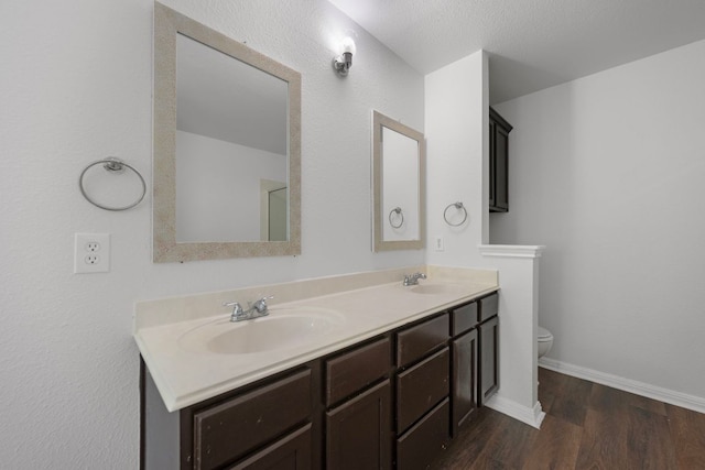 118 Cassandra Dr, Hutto, TX 78634 - bathroom featuring toilet, double vanity, wood finished floors, and baseboards