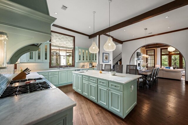 12724 Little Blue Stem Cv, Austin, TX 78738 - kitchen with green cabinets, arched walkways, light countertops, decorative backsplash, and ornamental molding