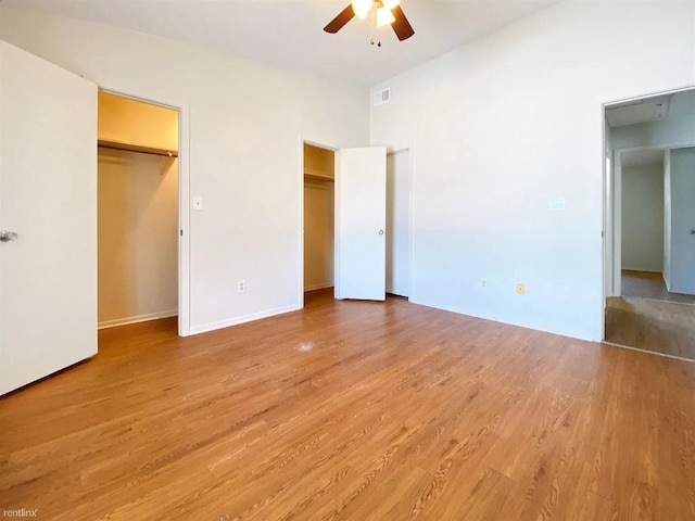 1604 Mill St Unit B, San Marcos, TX 78666 - unfurnished bedroom featuring two closets, light wood-style floors, a ceiling fan, and baseboards