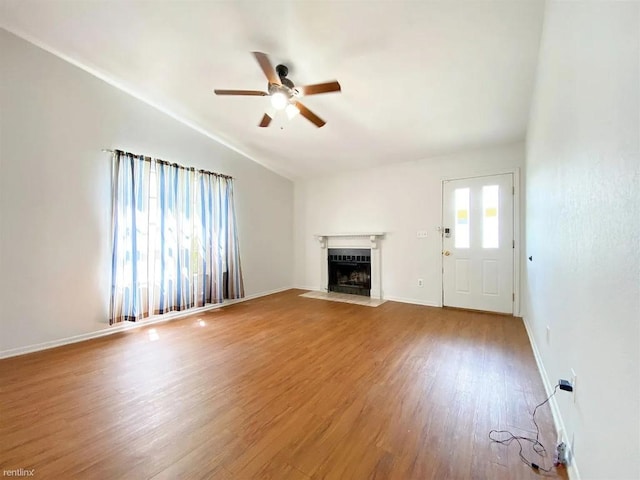 1604 Mill St Unit B, San Marcos, TX 78666 - unfurnished living room featuring ceiling fan, wood finished floors, a fireplace with flush hearth, and lofted ceiling