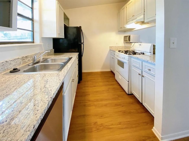 1604 Mill St Unit B, San Marcos, TX 78666 - kitchen with white range with gas cooktop, a sink, baseboards, light wood finished floors, and white cabinets