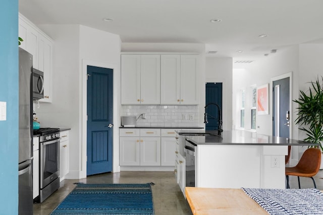2912 Govalle Ave Unit A, Austin, TX 78702 - kitchen with stainless steel appliances, finished concrete flooring, tasteful backsplash, white cabinets, and dark countertops