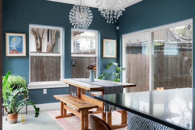 dining space with a chandelier, plenty of natural light, and baseboards