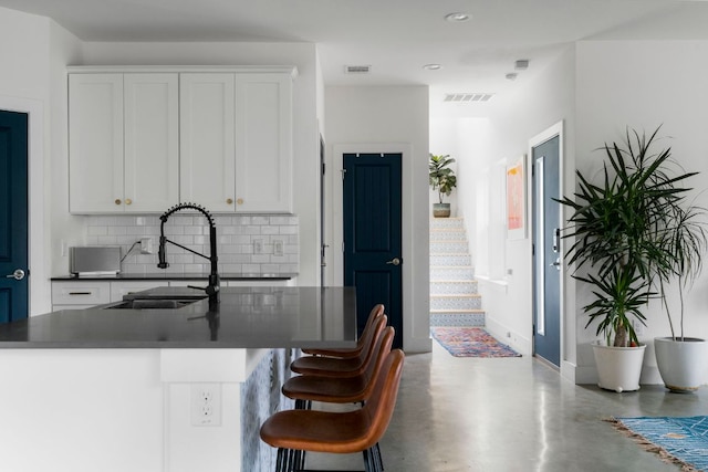 2912 Govalle Ave Unit A, Austin, TX 78702 - kitchen with tasteful backsplash, dark countertops, white cabinetry, concrete flooring, and recessed lighting