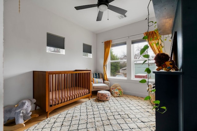 bedroom with a nursery area and wood finished floors