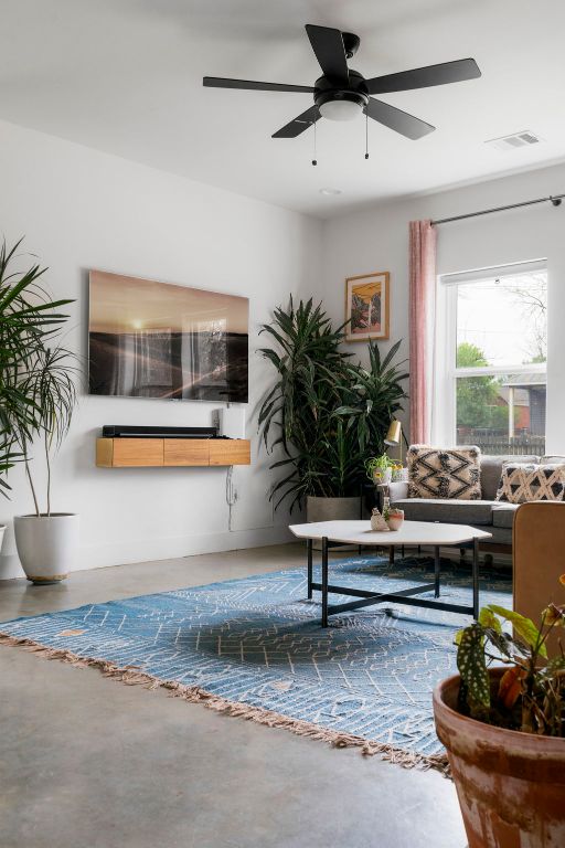 living area featuring concrete flooring and a ceiling fan