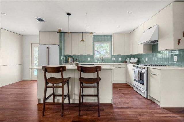 3605 Tallison Ter, Austin, TX 78704 - kitchen with under cabinet range hood, high end stainless steel range, a center island, and decorative backsplash