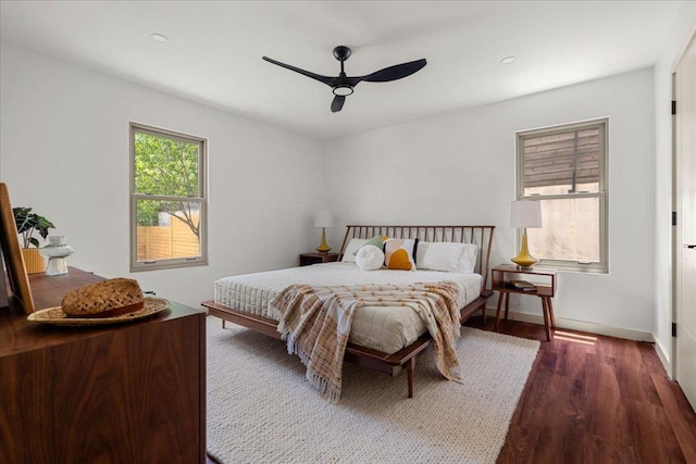 bedroom featuring dark wood-type flooring, ceiling fan, and baseboards