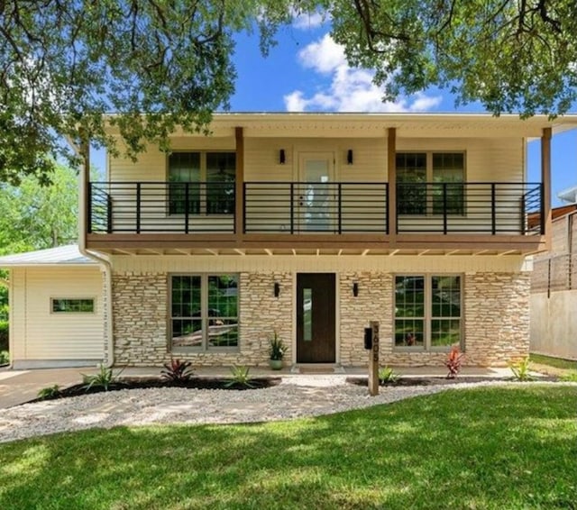 3605 Tallison Ter, Austin, TX 78704 - view of front of house with a balcony, a front lawn, and stone siding