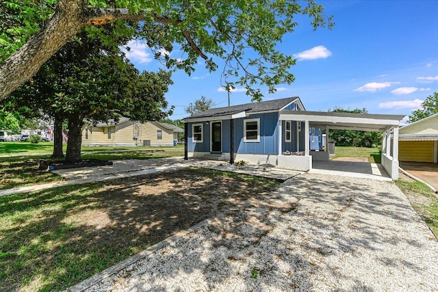 710 E 2nd St, Elgin, TX 78621 - view of front of house with board and batten siding, driveway, and an attached carport