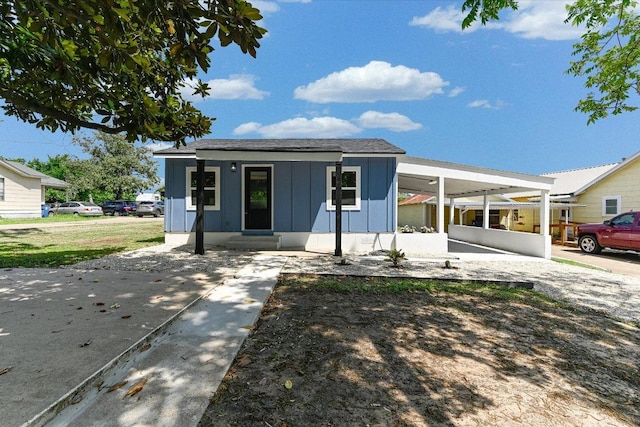 710 E 2nd St, Elgin, TX 78621 - view of front of property with board and batten siding, an attached carport, and entry steps