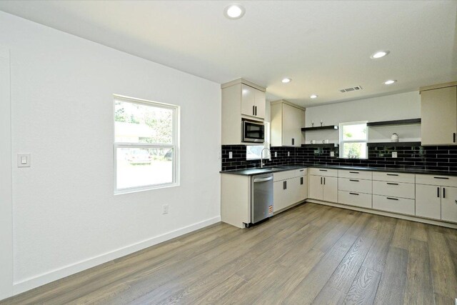710 E 2nd St, Elgin, TX 78621 - kitchen featuring open shelves, stainless steel appliances, dark countertops, backsplash, and recessed lighting