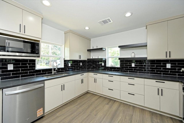 710 E 2nd St, Elgin, TX 78621 - kitchen with stainless steel appliances, open shelves, dark countertops, healthy amount of natural light, and recessed lighting