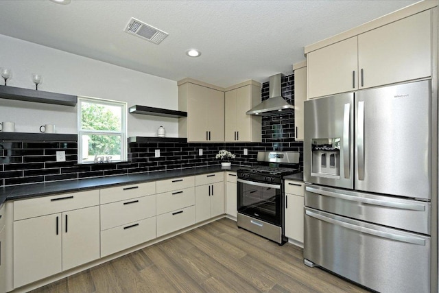 710 E 2nd St, Elgin, TX 78621 - kitchen with open shelves, stainless steel appliances, wall chimney range hood, dark countertops, and recessed lighting