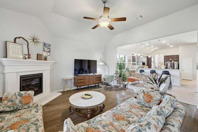 110 N Sage Holw, Dripping Springs, TX 78620 - living room featuring lofted ceiling, a ceiling fan, light wood-style flooring, and a glass covered fireplace