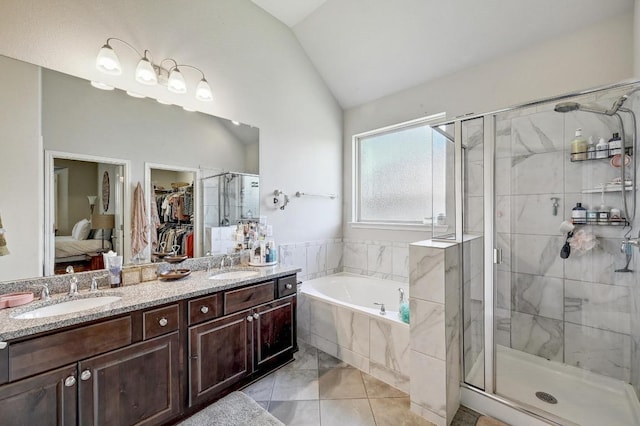 110 N Sage Holw, Dripping Springs, TX 78620 - bathroom with vaulted ceiling, a bath, a stall shower, double vanity, and a spacious closet
