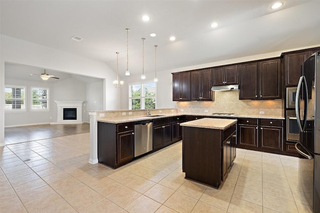 110 N Sage Holw, Dripping Springs, TX 78620 - kitchen featuring appliances with stainless steel finishes, under cabinet range hood, lofted ceiling, backsplash, and light tile patterned flooring