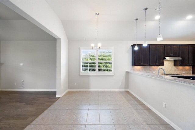 110 N Sage Holw, Dripping Springs, TX 78620 - kitchen with a chandelier, decorative backsplash, lofted ceiling, under cabinet range hood, and dark brown cabinets