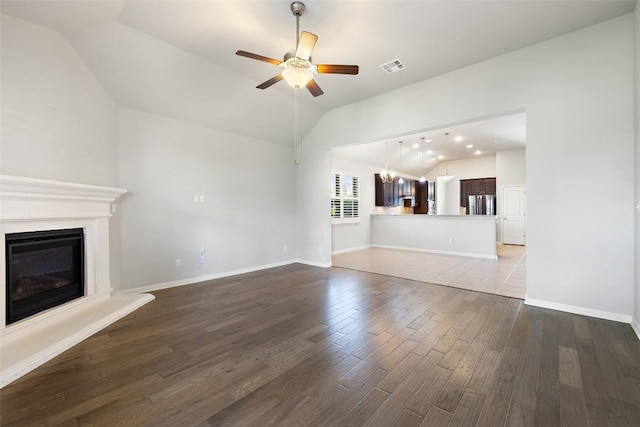 110 N Sage Holw, Dripping Springs, TX 78620 - unfurnished living room with vaulted ceiling, ceiling fan, wood finished floors, and a glass covered fireplace