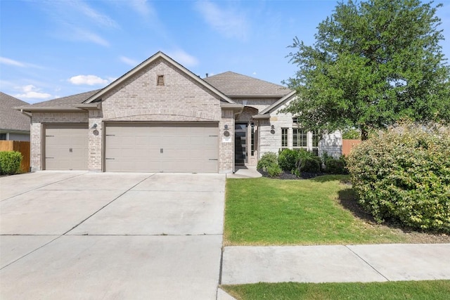110 N Sage Holw, Dripping Springs, TX 78620 - view of front facade featuring an attached garage, driveway, a front lawn, and brick siding