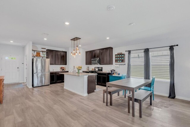 200 Waterway Ave, Hutto, TX 78634 - kitchen with appliances with stainless steel finishes, dark brown cabinets, light wood-type flooring, pendant lighting, and recessed lighting